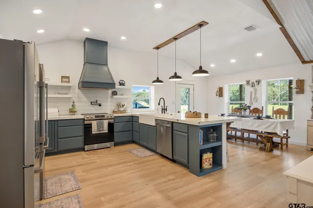 a kitchen with stainless steel appliances kitchen island granite countertop a stove and a refrigerator