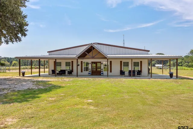 a view of a house with swimming pool and a yard