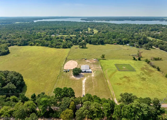 an aerial view of ocean with residential house and outdoor space