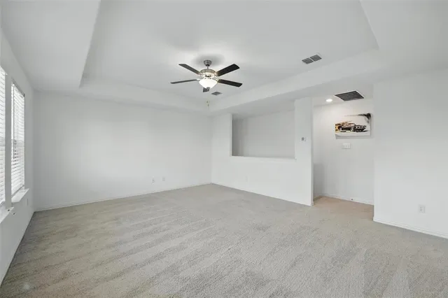 an empty room with fan and windows