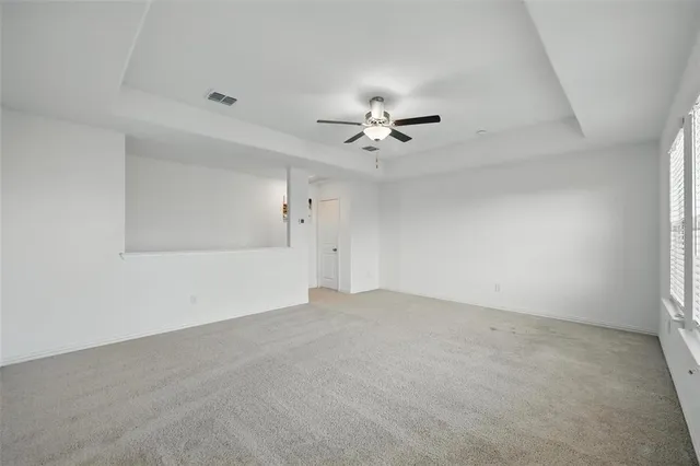 an empty room with a bathroom and a ceiling fan