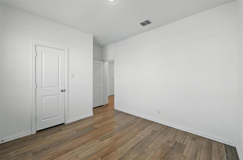 613 Chip Street Little Elm, TX 75068 - Photo 19 of 37 Unfurnished bedroom featuring baseboards and wood finished floors