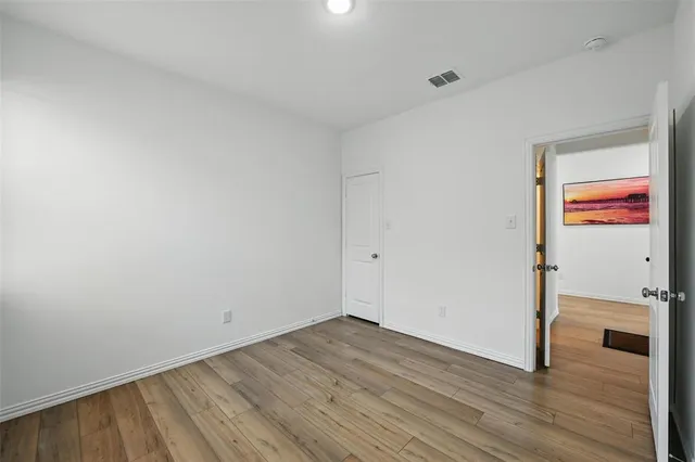 a view of a room with wooden floor and white walls