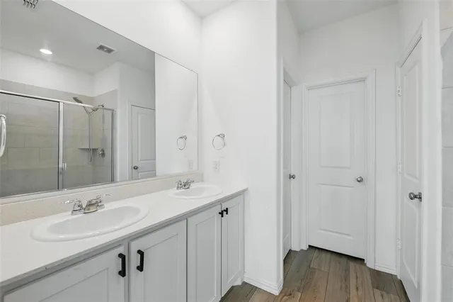 a bathroom with a sink double vanity granite tub and shower