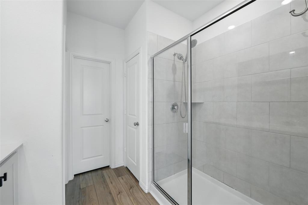 613 Chip Street Little Elm, TX 75068 - Photo 27 of 37 Full bathroom featuring light wood finished floors, a shower stall, and vanity