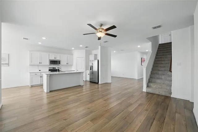 a view of kitchen with refrigerator microwave and wooden floor
