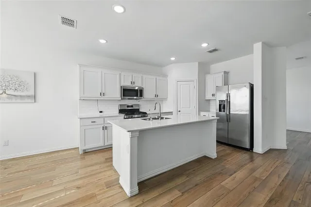 a kitchen with stainless steel appliances a refrigerator stove microwave and cabinets