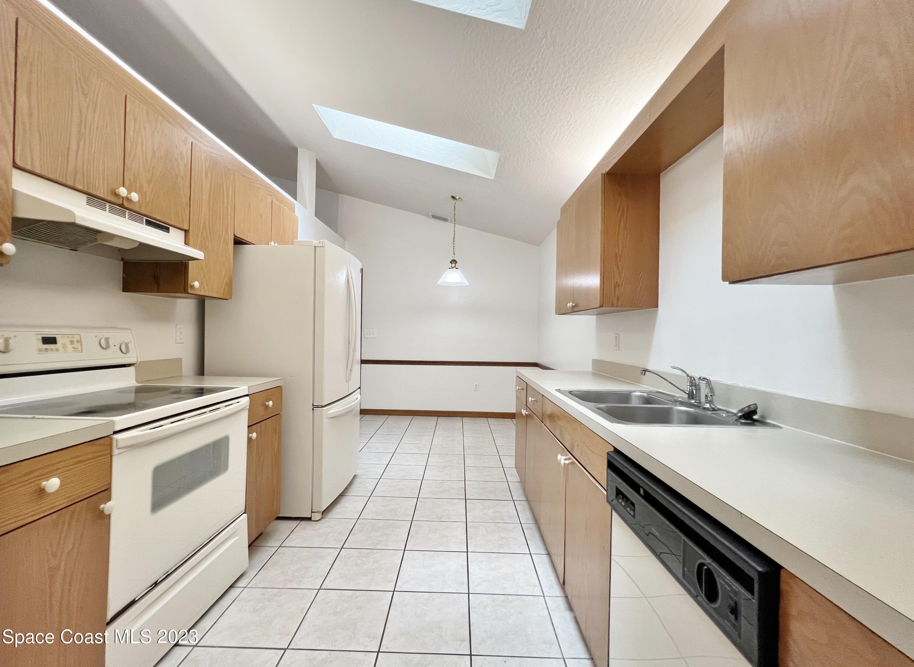 1054 South Fork Circle Melbourne, FL 32901 - Photo 3 of 16 a kitchen with a sink and white cabinets