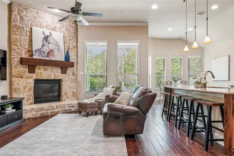 a living room with furniture a fireplace and a chandelier