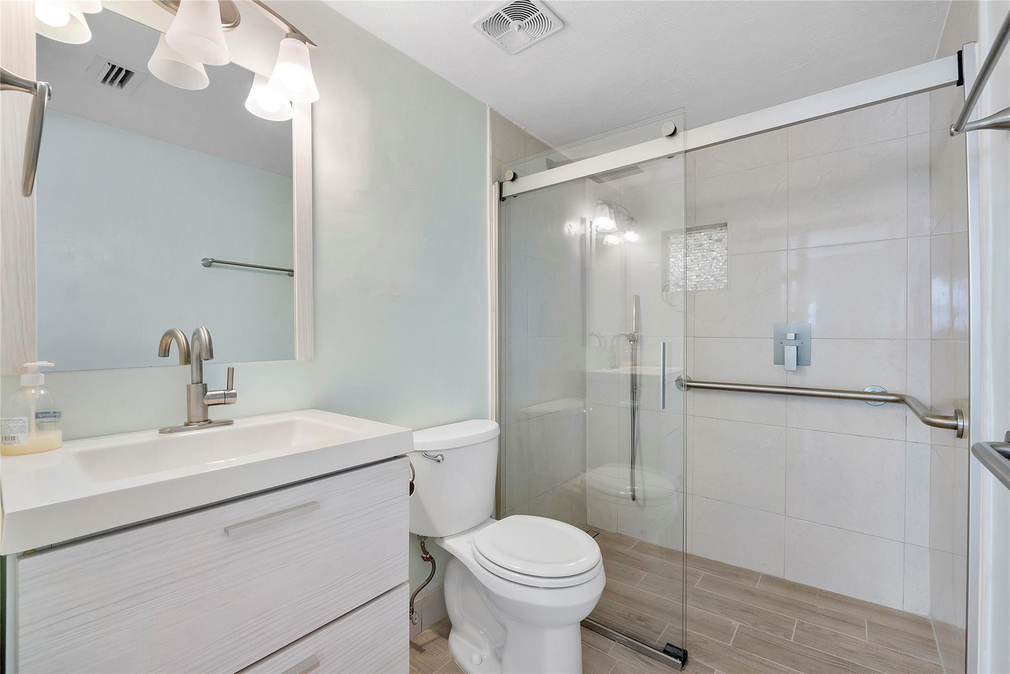 1951 Northeast 39th Street, Unit 156 Lighthouse Point, FL 33064 - Photo 14 of 43 a bathroom with a sink toilet vanity and shower