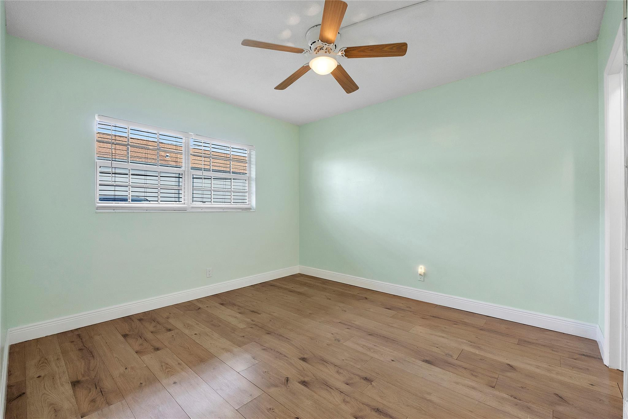 1951 Northeast 39th Street, Unit 156 Lighthouse Point, FL 33064 - Photo 17 of 43 an empty room with wooden floor fan and windows