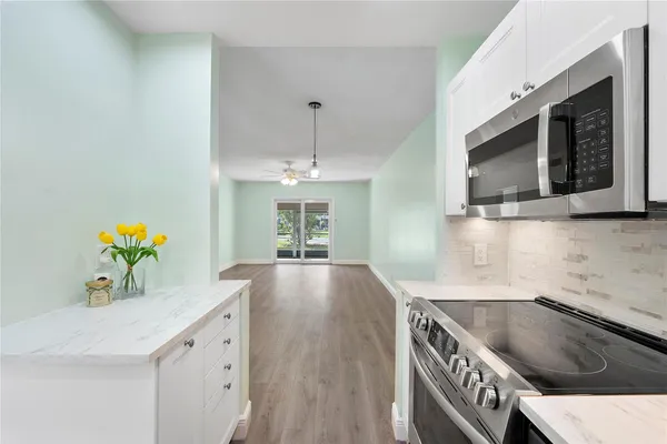 a kitchen with stove cabinets and chandelier