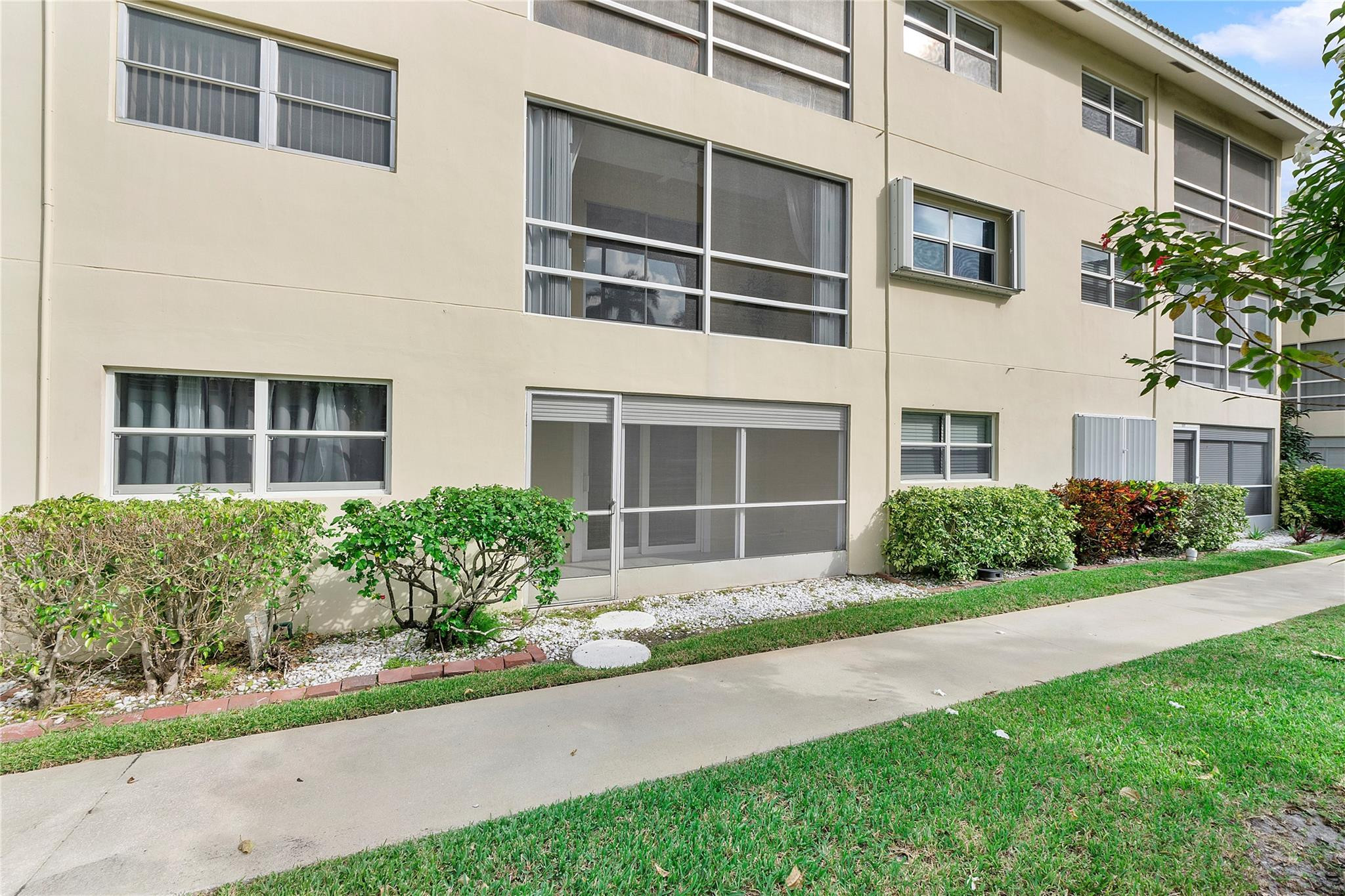 1951 Northeast 39th Street, Unit 156 Lighthouse Point, FL 33064 - Photo 28 of 43 a front view of a building with garden