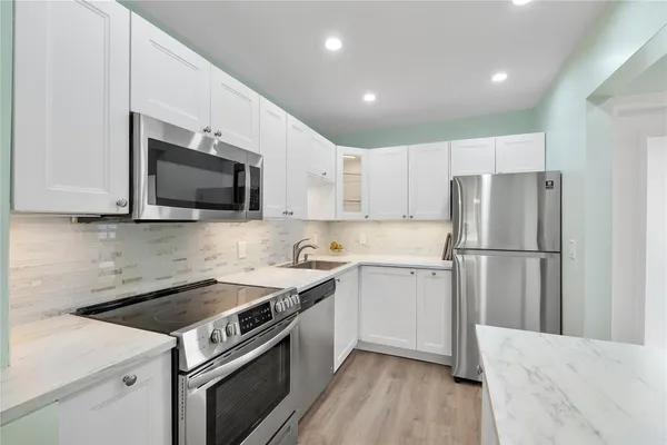 a kitchen with a sink a stove top oven and refrigerator