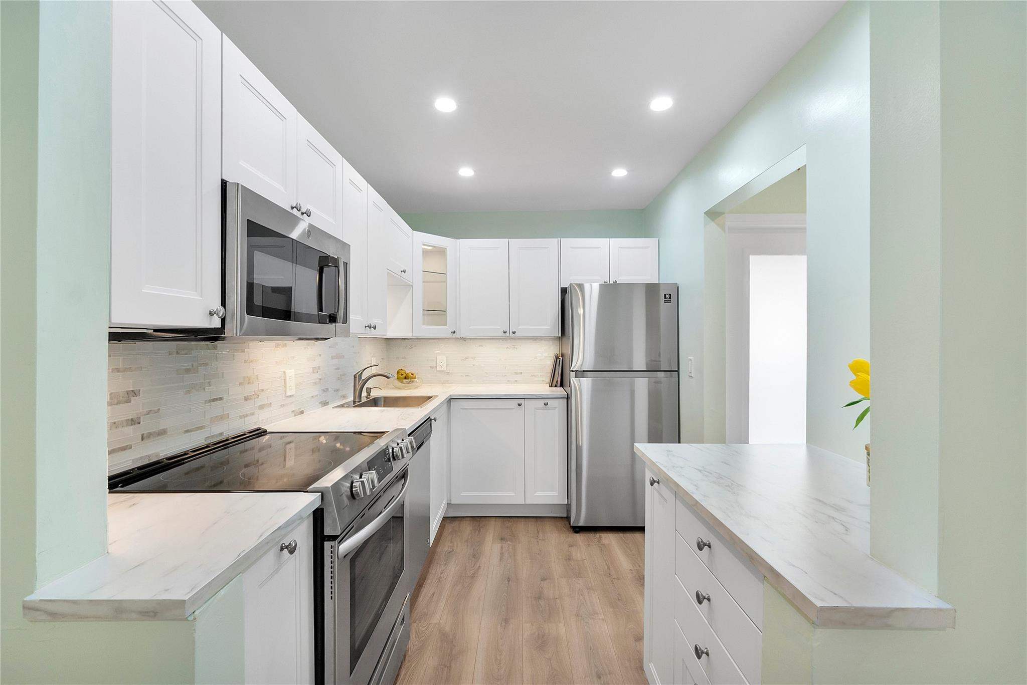 1951 Northeast 39th Street, Unit 156 Lighthouse Point, FL 33064 - Photo 5 of 43 a kitchen with a sink a microwave a stove and refrigerator