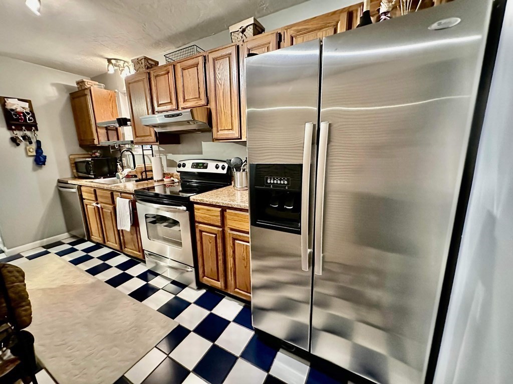 1195 Grafton Street, Unit 12 Worcester, MA 01604 - Photo 2 of 17 a kitchen with stainless steel appliances granite countertop a refrigerator a sink a stove and white cabinets
