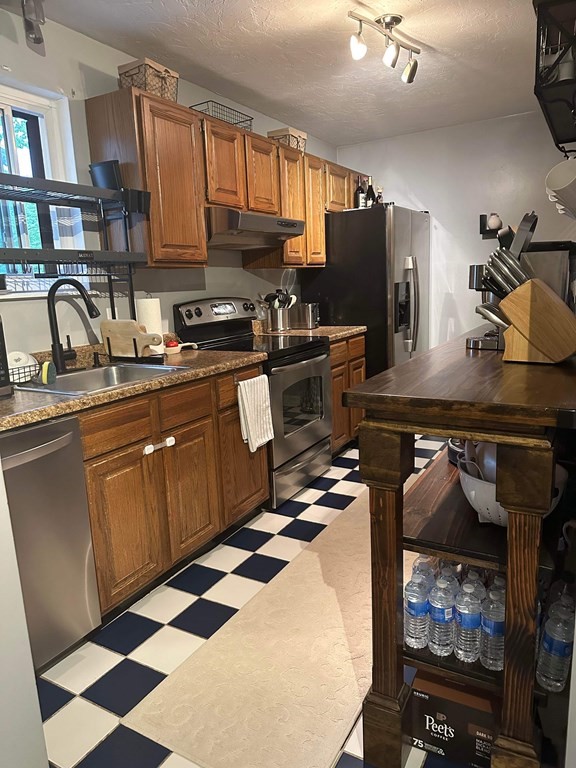 1195 Grafton Street, Unit 12 Worcester, MA 01604 - Photo 5 of 17 a kitchen with stainless steel appliances granite countertop a sink wooden cabinets and a stove