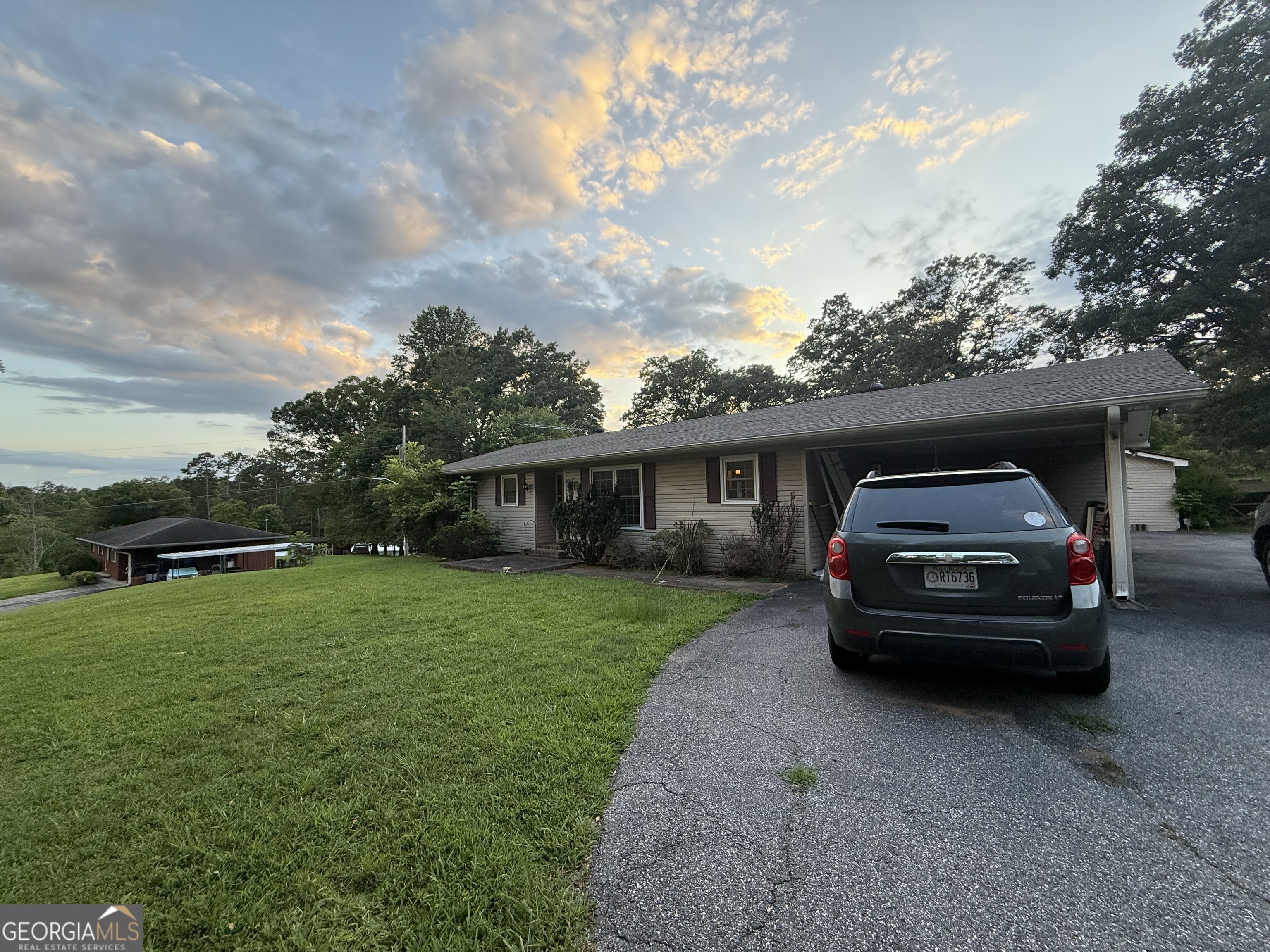 a car parked in front of a house and a yard