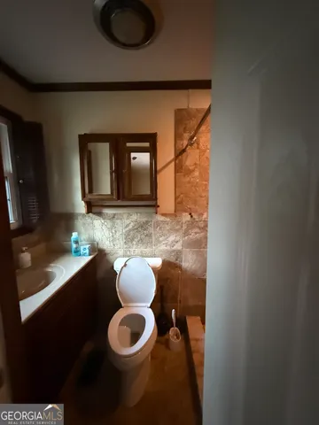 a bathroom with a toilet sink and mirror