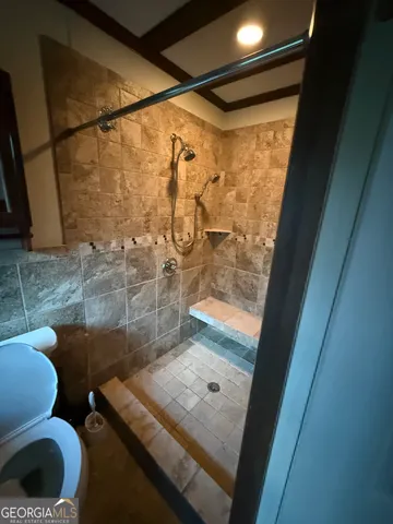 a bathroom with a toilet and a shower