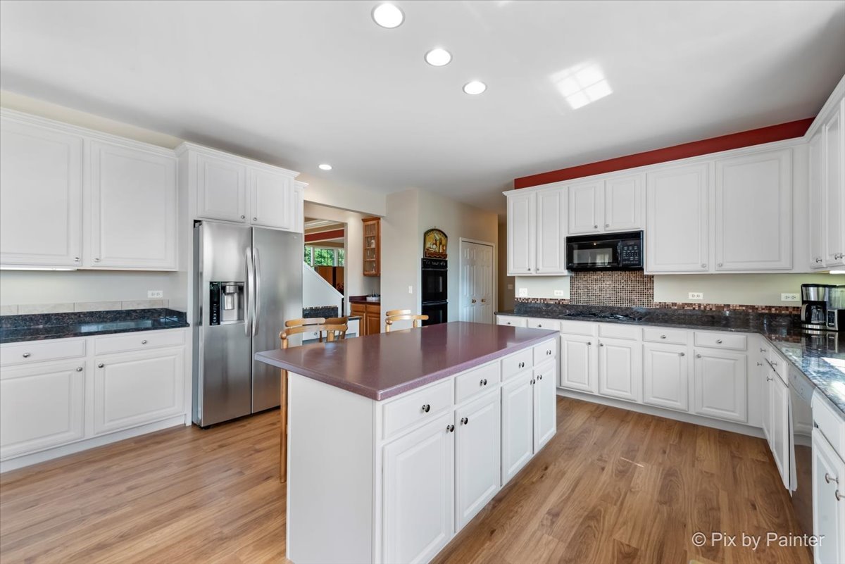 8475 Watson Circle Lakewood, IL 60014 - Photo 11 of 49 a kitchen with white cabinets sink and stainless steel appliances