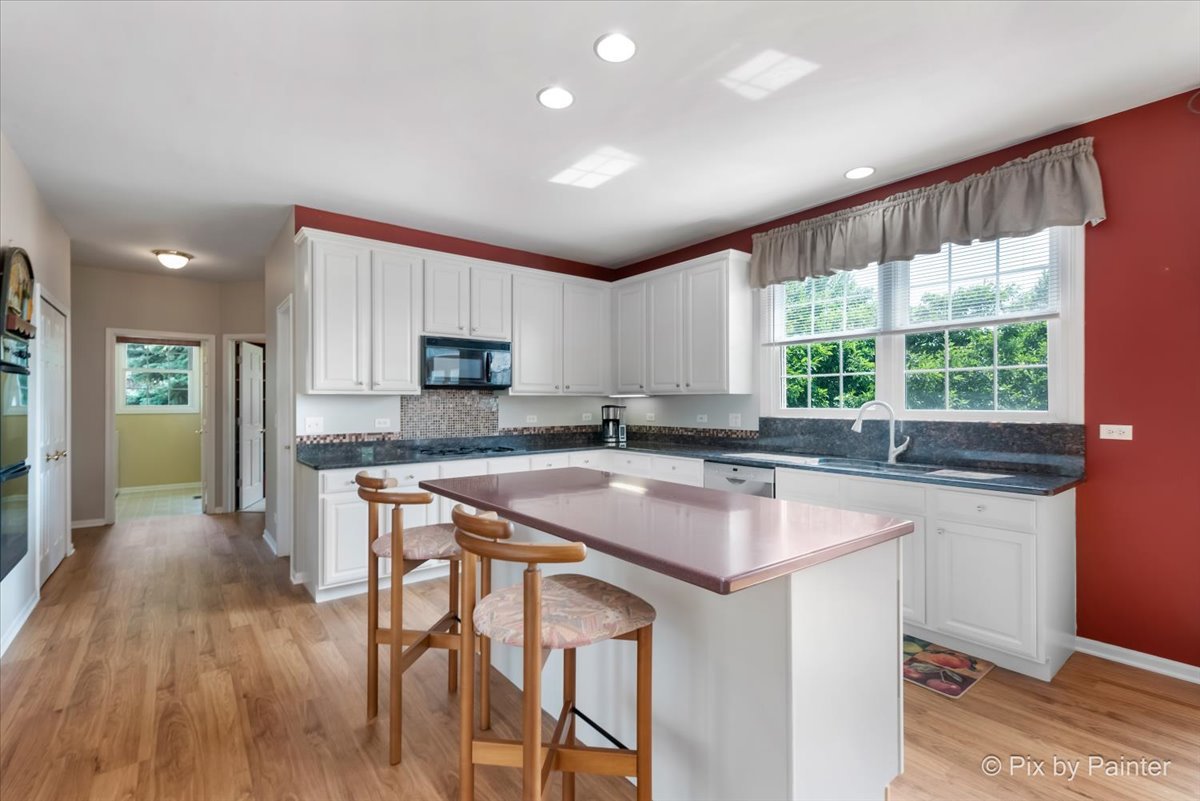 8475 Watson Circle Lakewood, IL 60014 - Photo 12 of 49 a kitchen with wooden floors and wooden cabinets