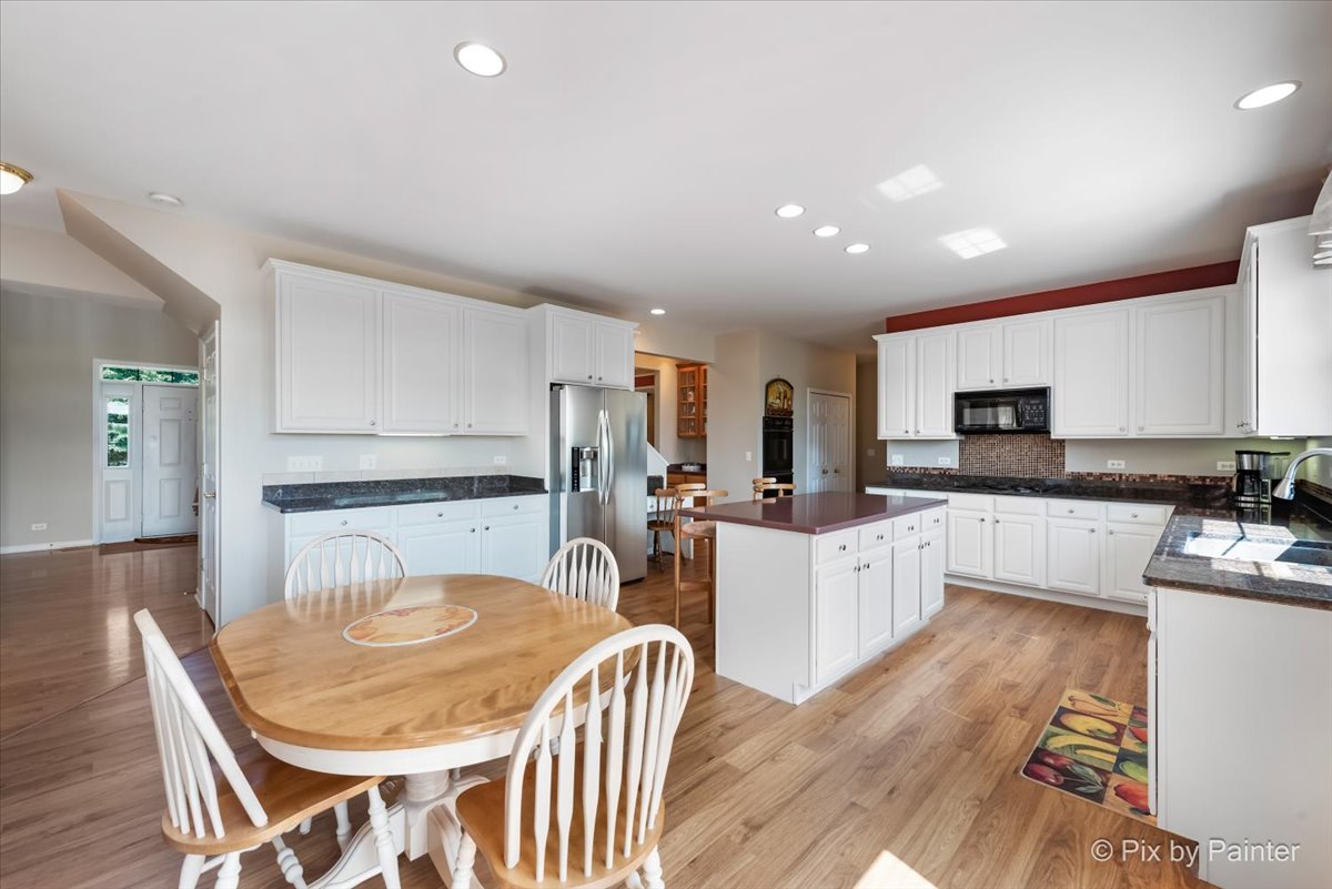 8475 Watson Circle Lakewood, IL 60014 - Photo 13 of 49 a kitchen with granite countertop white cabinets and stainless steel appliances