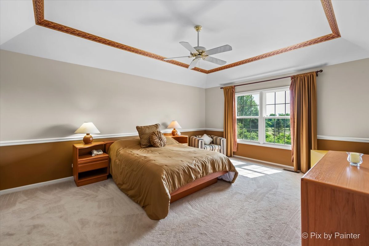 8475 Watson Circle Lakewood, IL 60014 - Photo 25 of 49 a bedroom with a bed and a chandelier