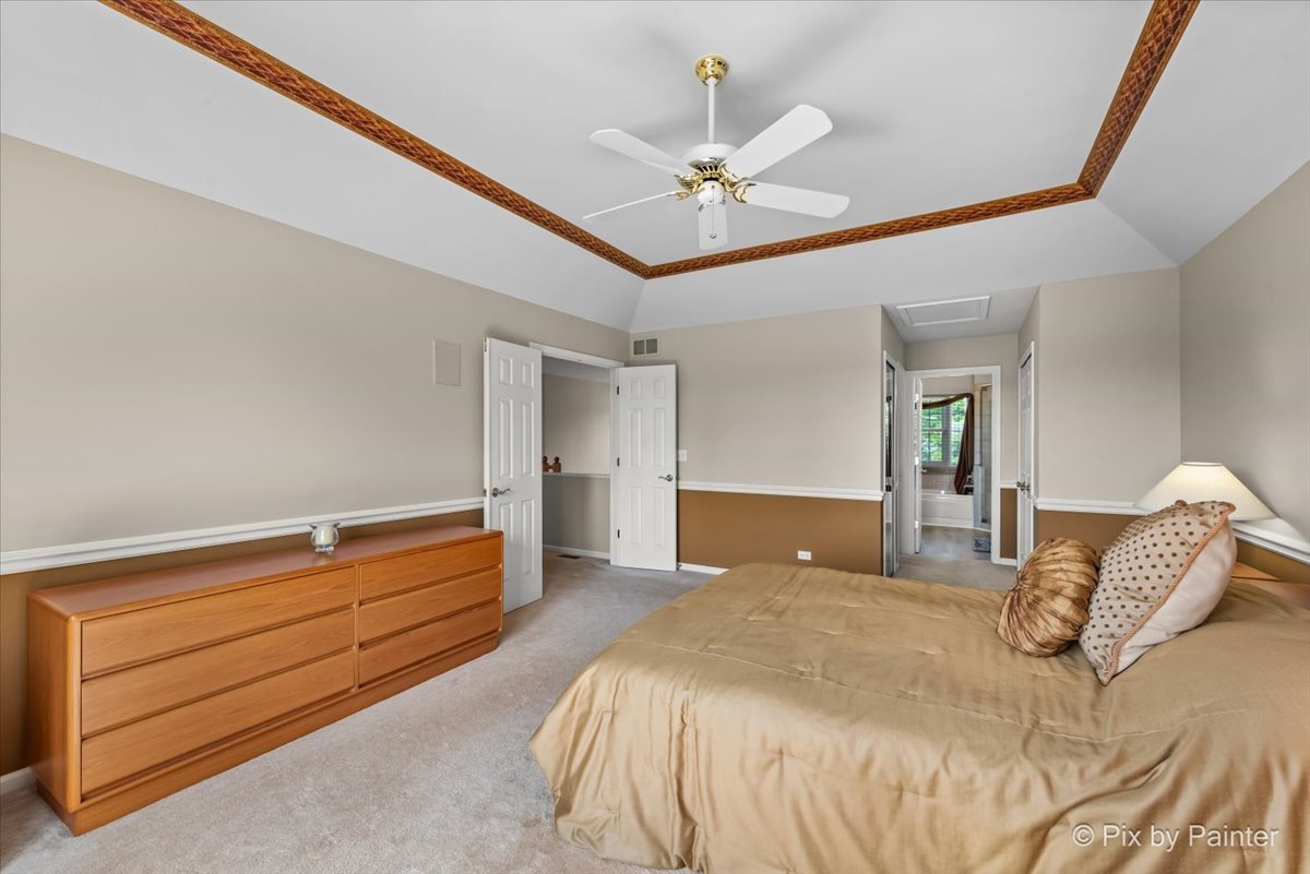 8475 Watson Circle Lakewood, IL 60014 - Photo 26 of 49 a bedroom with a bed and a chandelier
