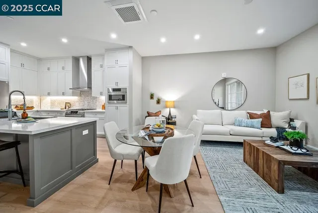 a living room with kitchen island furniture and a chandelier