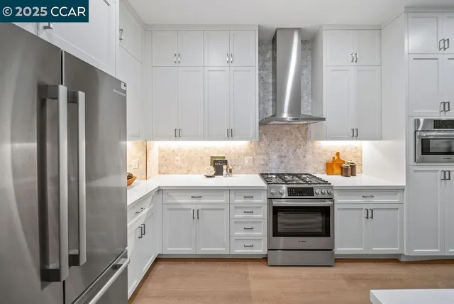 a kitchen with stainless steel appliances granite countertop a refrigerator stove and sink