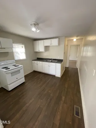 a large kitchen with stainless steel appliances a large counter top a stove a chimney a sink and a refrigerator