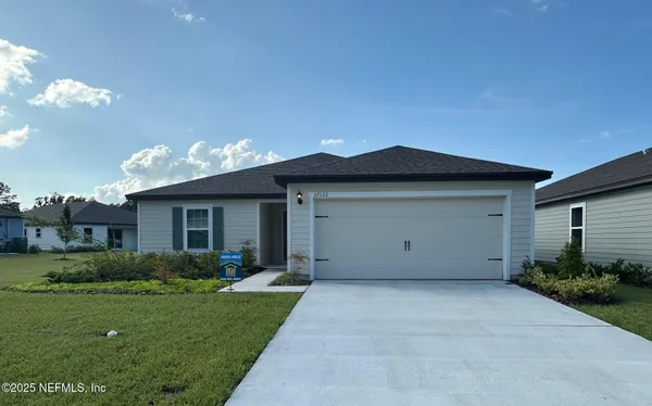 a view of a house with a yard and garage