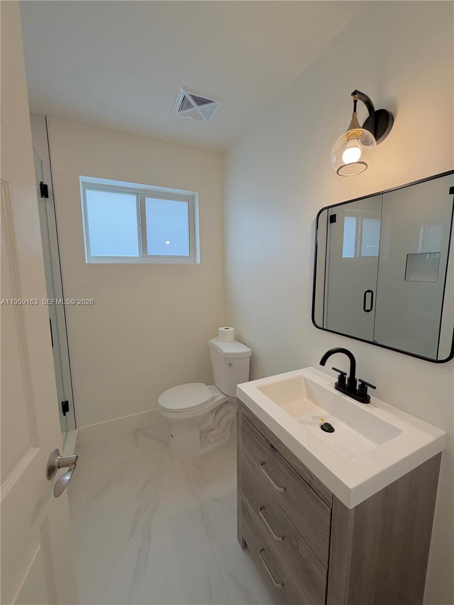 19221 Southwest 92nd Road Cutler Bay, FL 33157 - Photo 20 of 30 a bathroom with a sink mirror and toilet