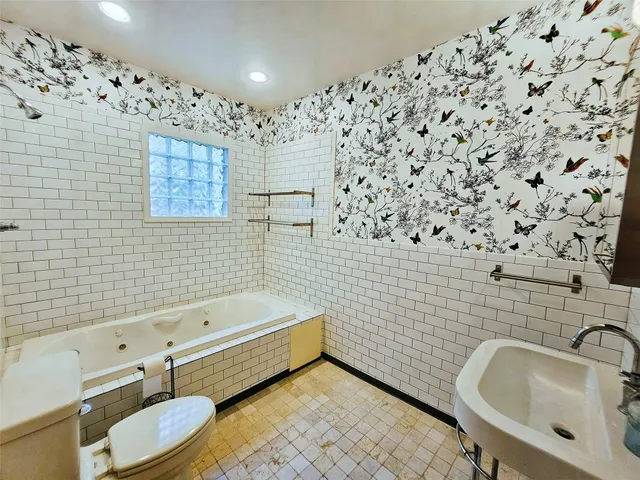 a bathroom with a toilet sink and mirror