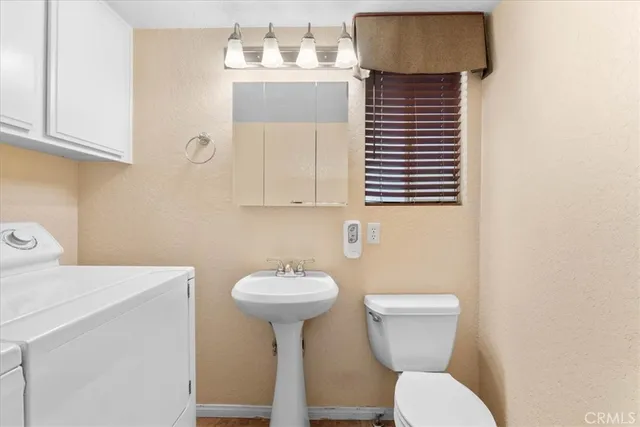 a bathroom with a sink toilet and mirror