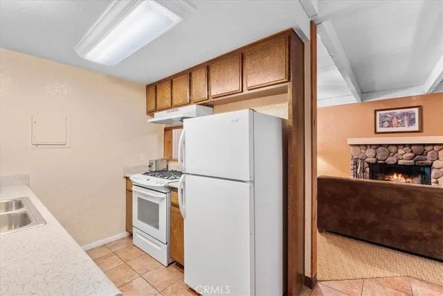 a kitchen with stainless steel appliances granite countertop a refrigerator a stove and a sink with cabinets