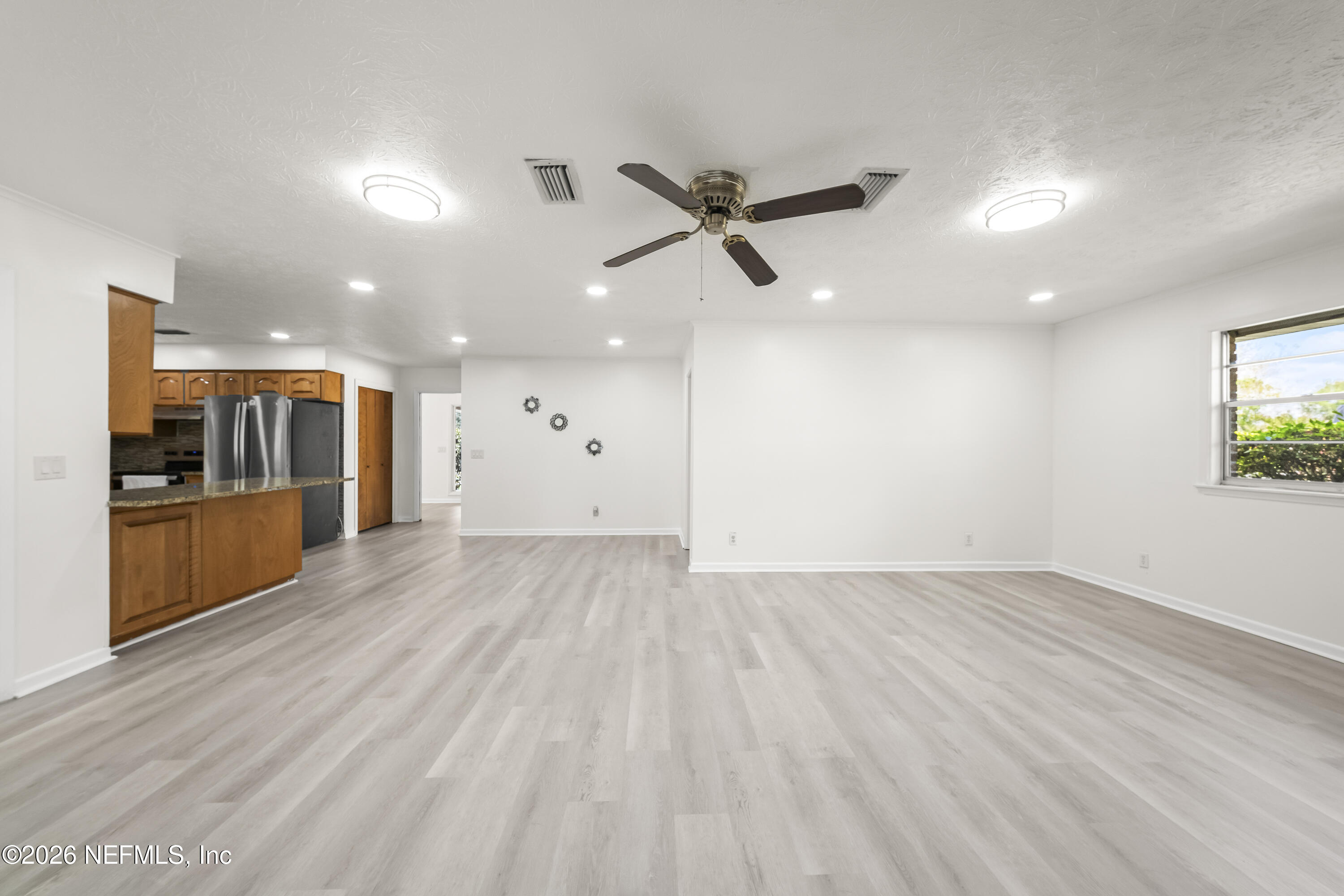 3571 Sandburg Road Jacksonville, FL 32277 - Photo 13 of 41 a view of a big room with wooden floor and a kitchen