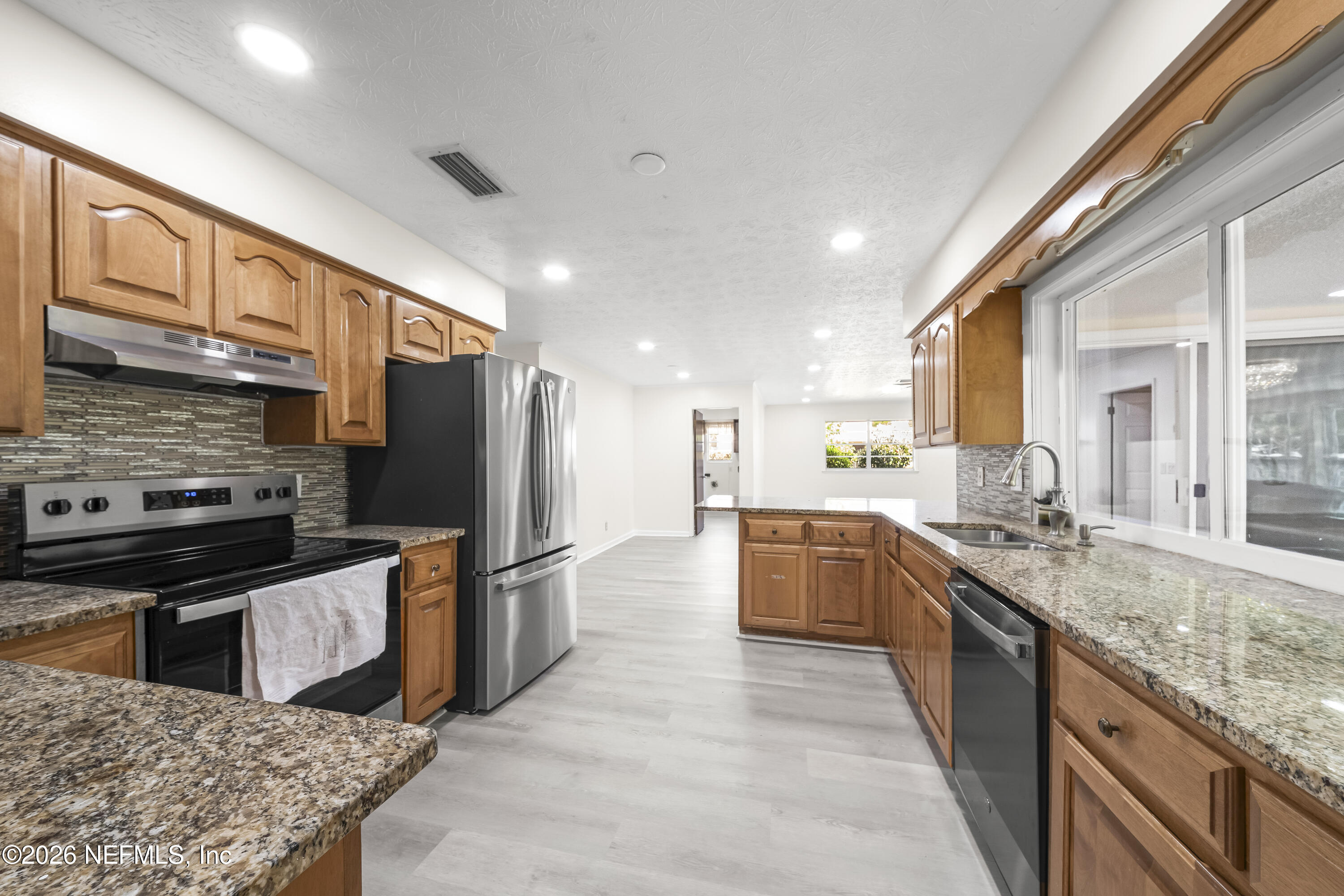 3571 Sandburg Road Jacksonville, FL 32277 - Photo 23 of 41 a large kitchen with stainless steel appliances kitchen island granite countertop a large counter top stainless steel appliances and cabinets
