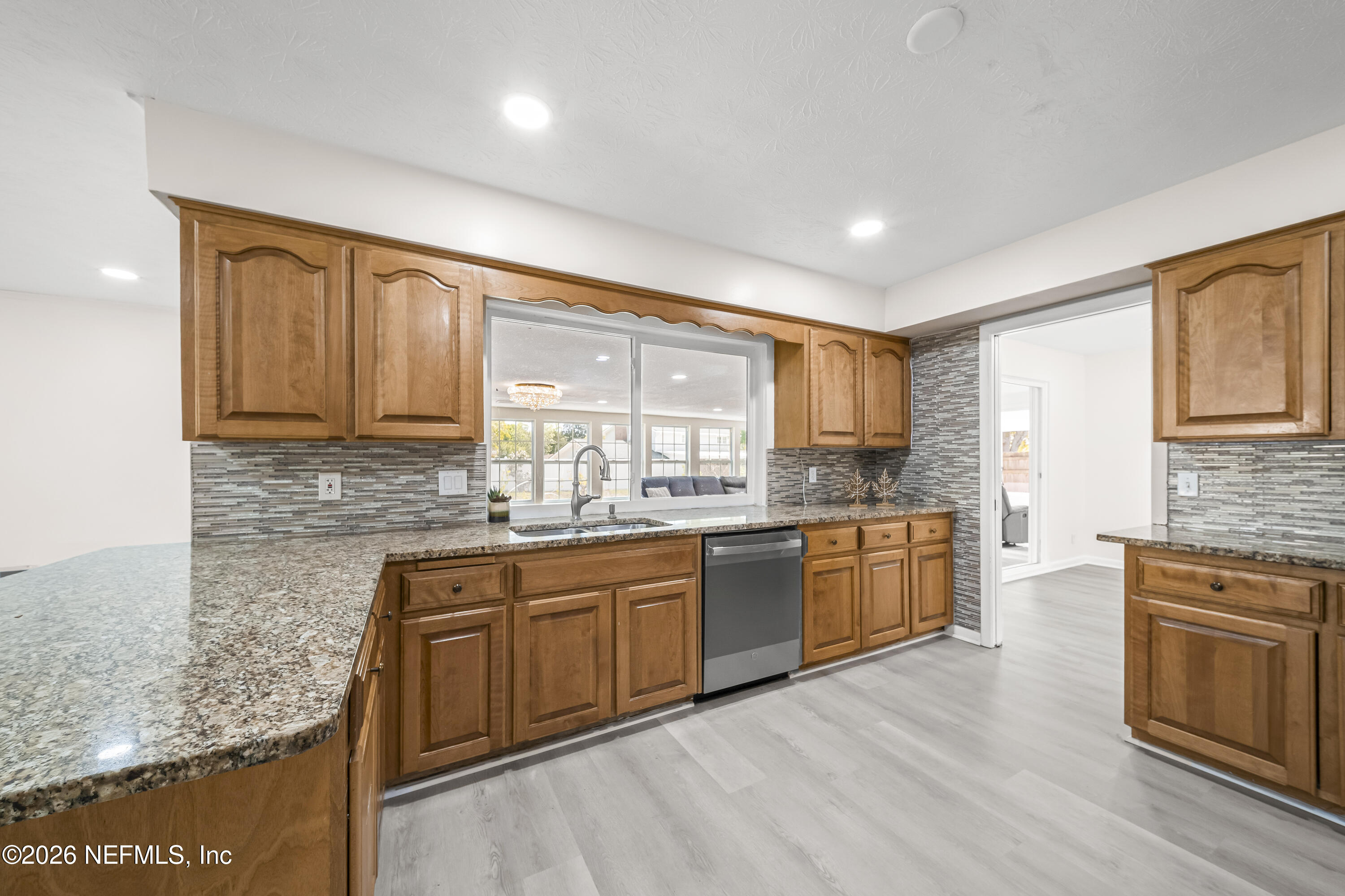 3571 Sandburg Road Jacksonville, FL 32277 - Photo 24 of 41 a large kitchen with granite countertop cabinets stainless steel appliances a sink and a large window