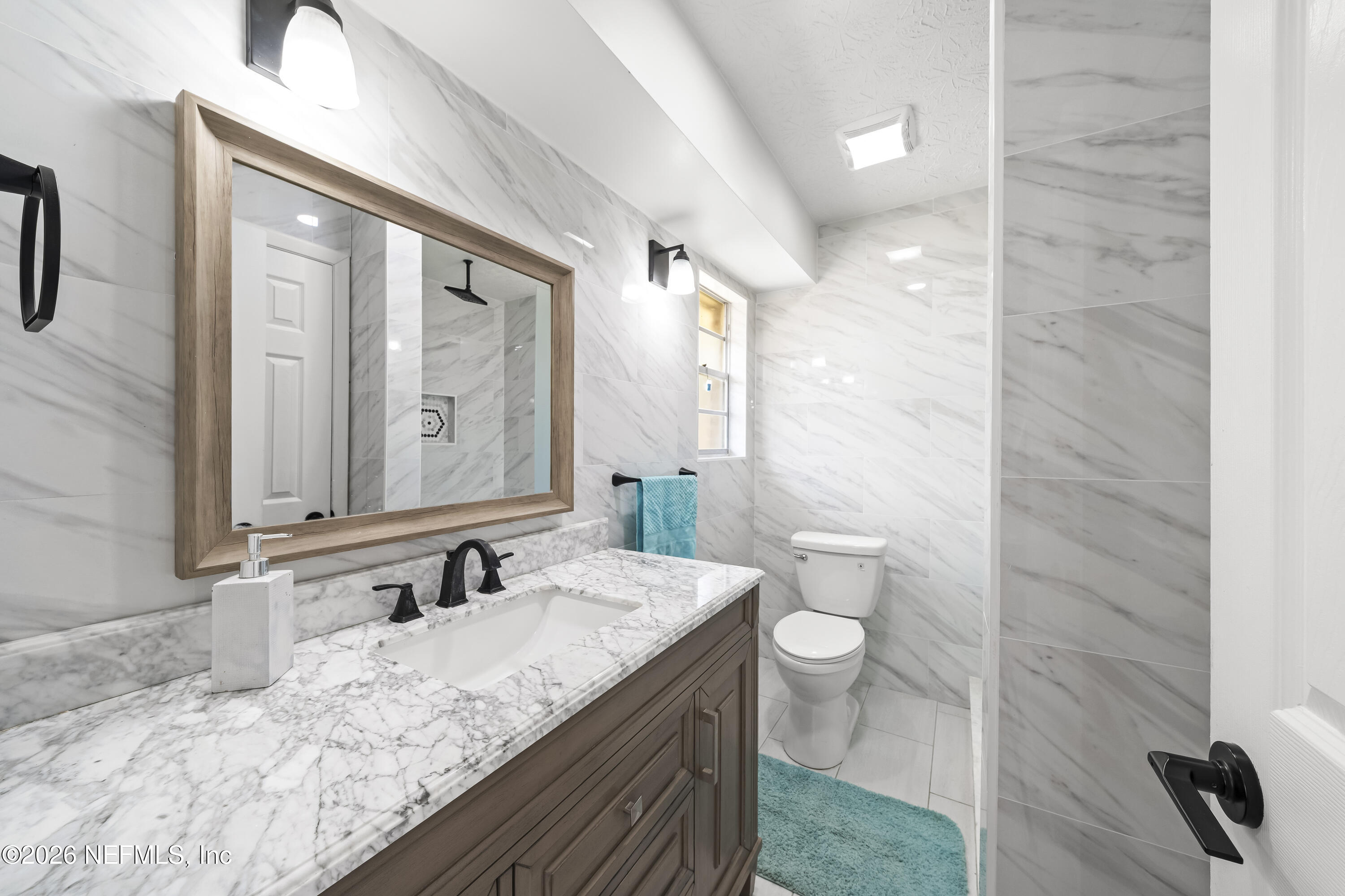 3571 Sandburg Road Jacksonville, FL 32277 - Photo 32 of 41 a bathroom with a granite countertop sink a toilet and a mirror