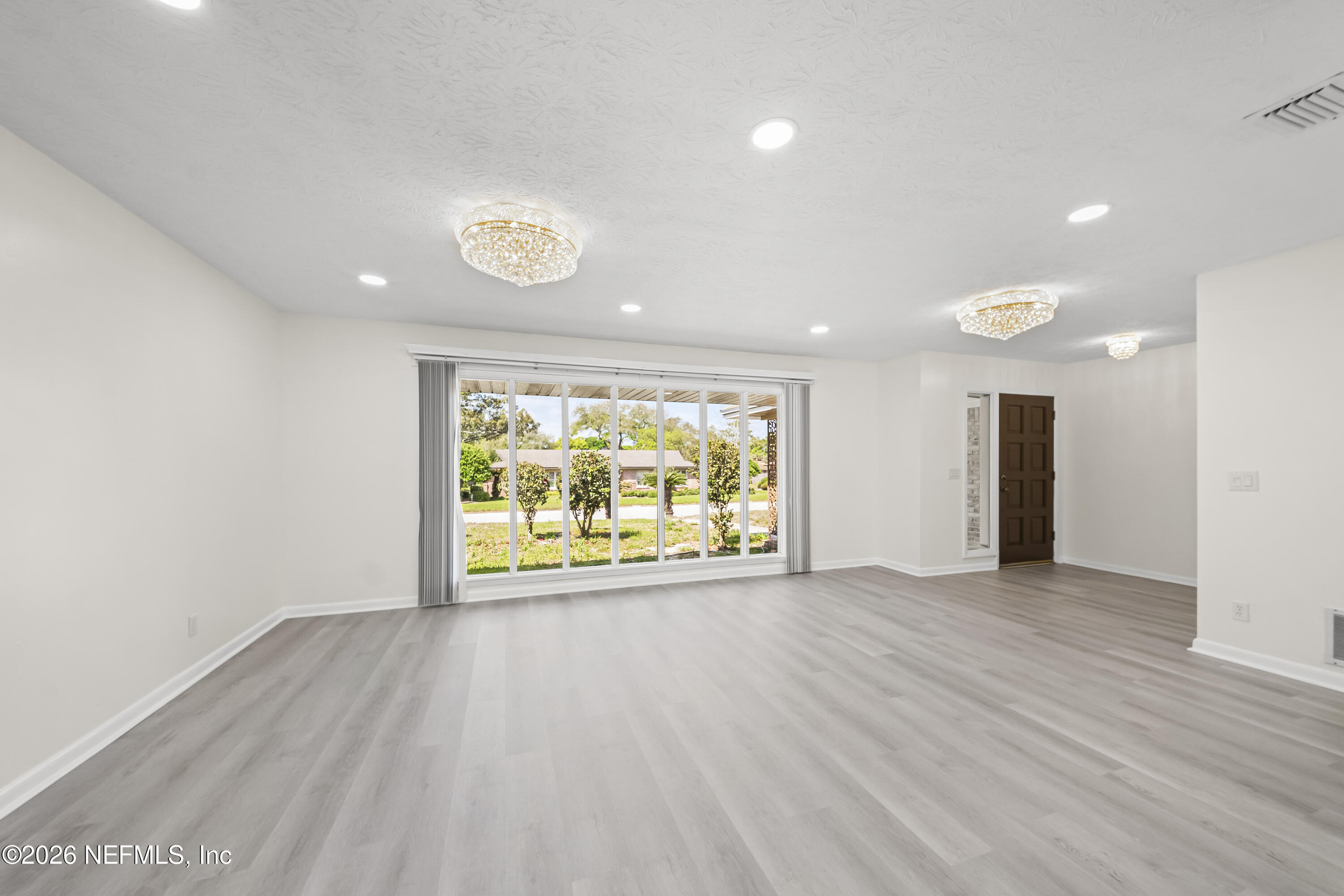 3571 Sandburg Road Jacksonville, FL 32277 - Photo 8 of 41 an empty room with wooden floor and a window