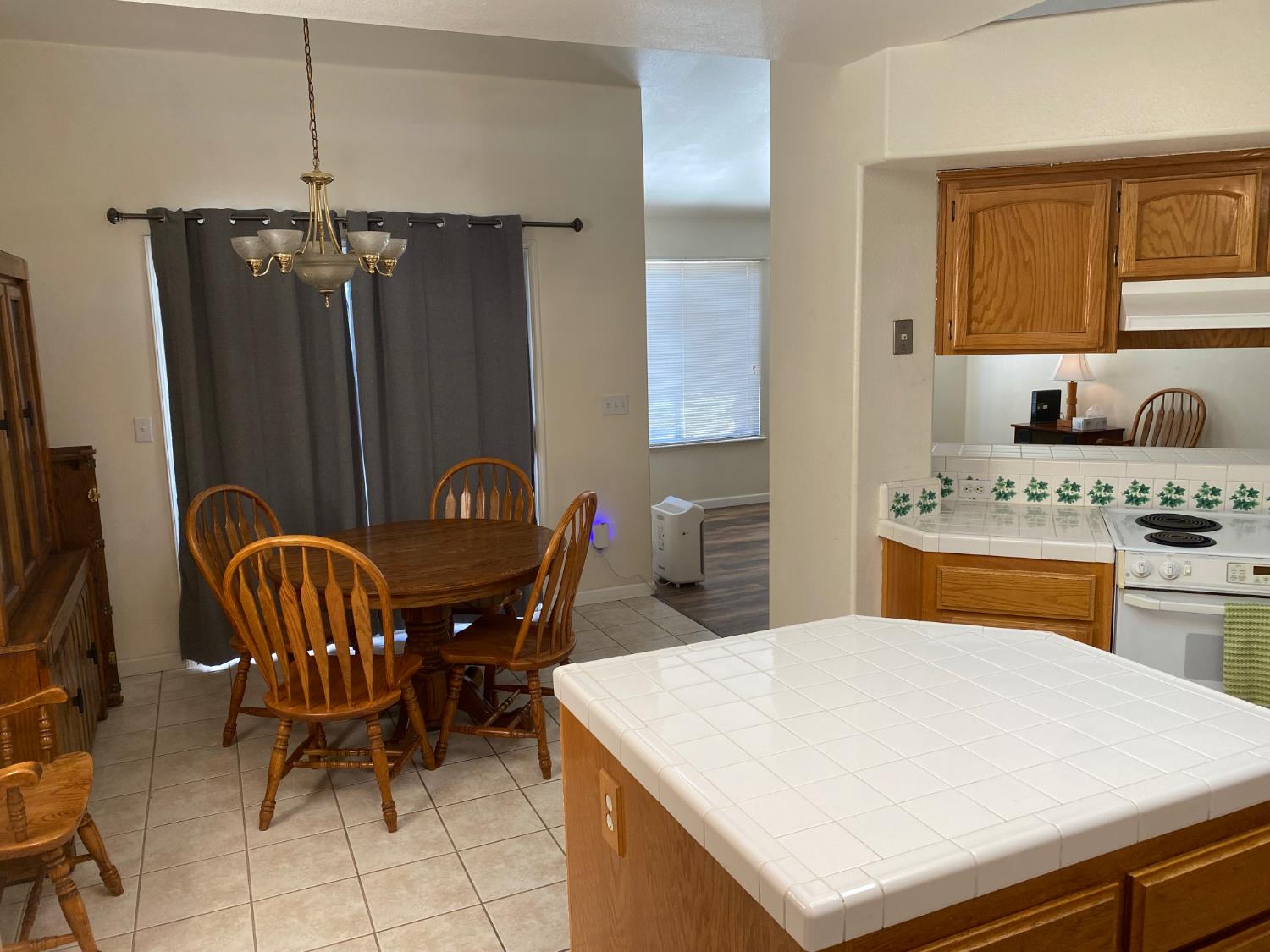 609 Merlot Avenue Madera, CA 93637 - Photo 9 of 45 a kitchen with stainless steel appliances kitchen island granite countertop a table chairs and a refrigerator