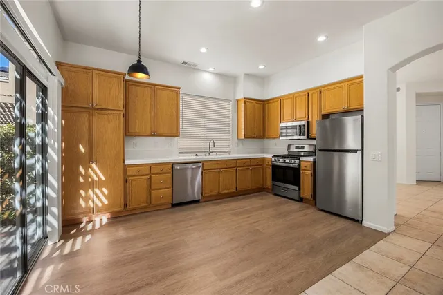 a kitchen with stainless steel appliances granite countertop a refrigerator a sink a stove a microwave and island