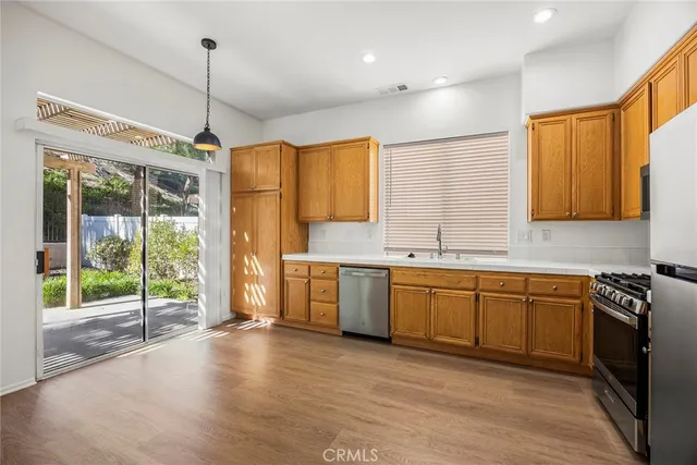 a kitchen with stainless steel appliances granite countertop a stove a sink and a refrigerator