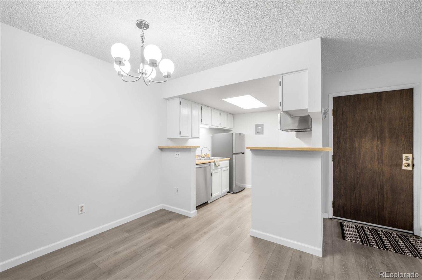 4400 South Quebec Street, Unit 102V Denver, CO 80237 - Photo 12 of 21 a view of a kitchen with a sink dishwasher a refrigerator and wooden floor