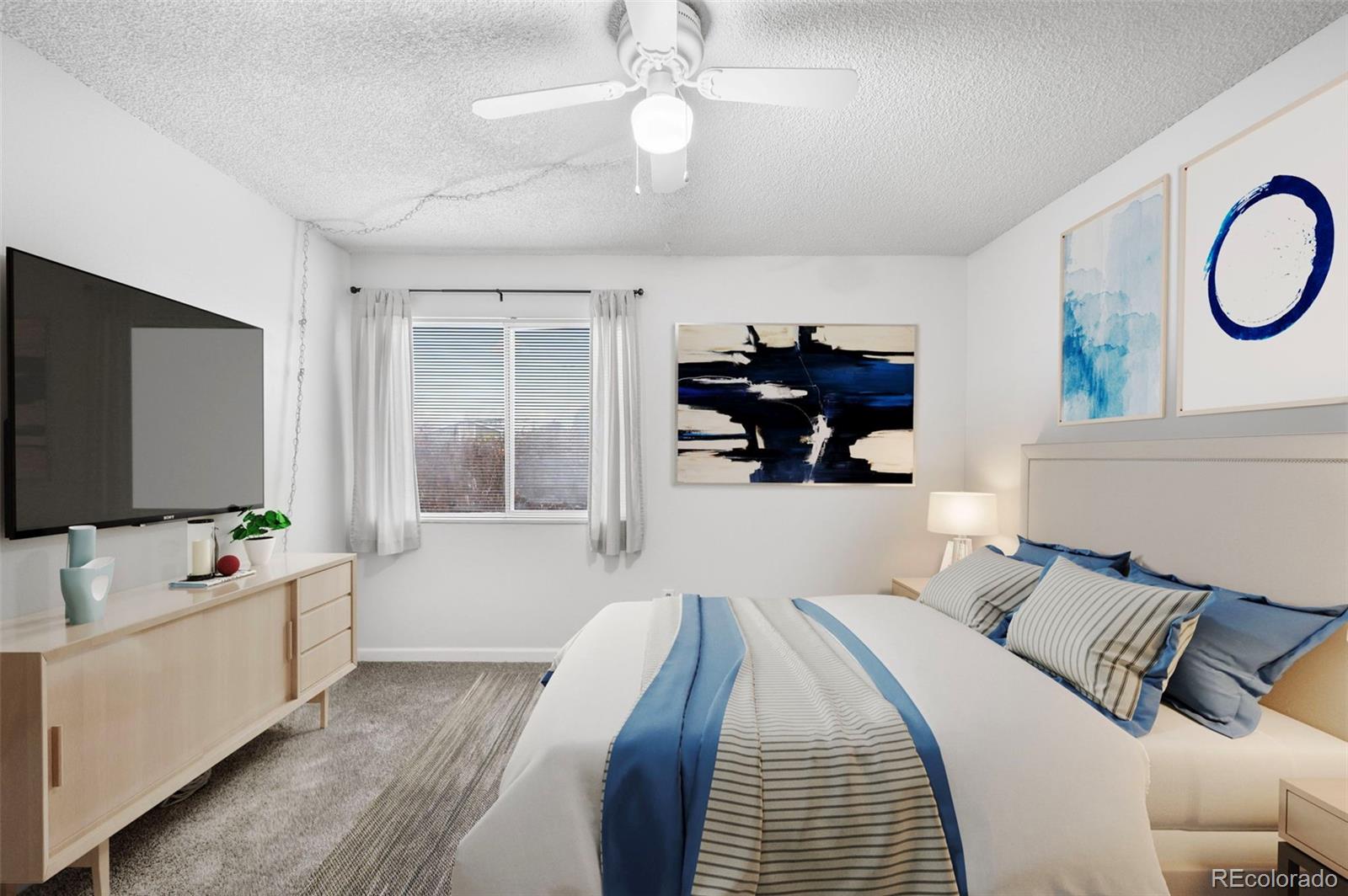 4400 South Quebec Street, Unit 102V Denver, CO 80237 - Photo 14 of 21 a bedroom with bed and a flat tv screen on dresser