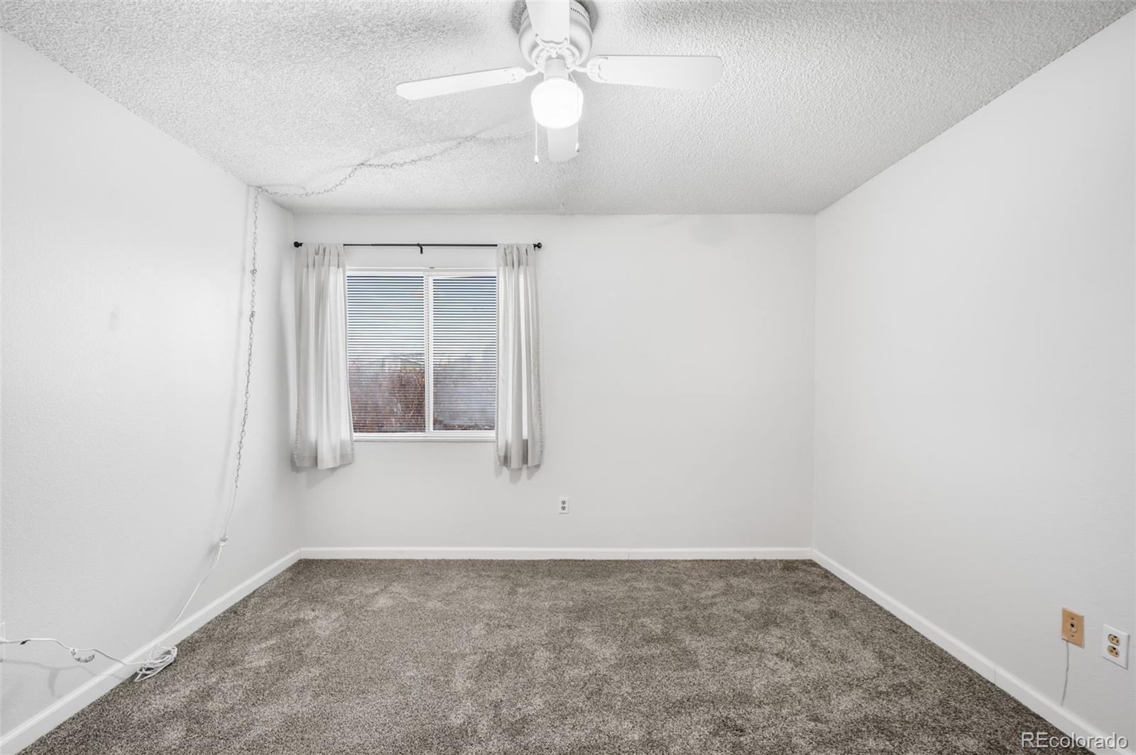 4400 South Quebec Street, Unit 102V Denver, CO 80237 - Photo 15 of 21 an empty room with a empty space and a ceiling fan