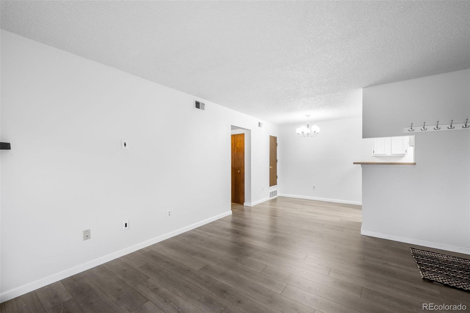 4400 South Quebec Street, Unit 102V Denver, CO 80237 - Photo 7 of 21 a view of an empty room with wooden floor