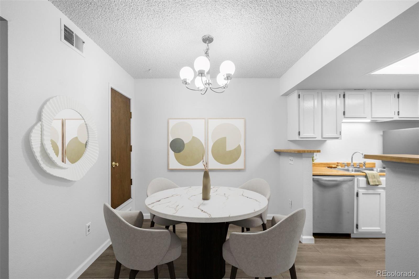 4400 South Quebec Street, Unit 102V Denver, CO 80237 - Photo 10 of 21 a dining room with stainless steel appliances a table chairs and a chandelier